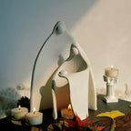 Ceramic family candle holder on a wooden table with burning tealights