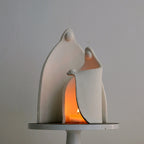 Ceramic sculpture of a family with a candle inside on a gray background