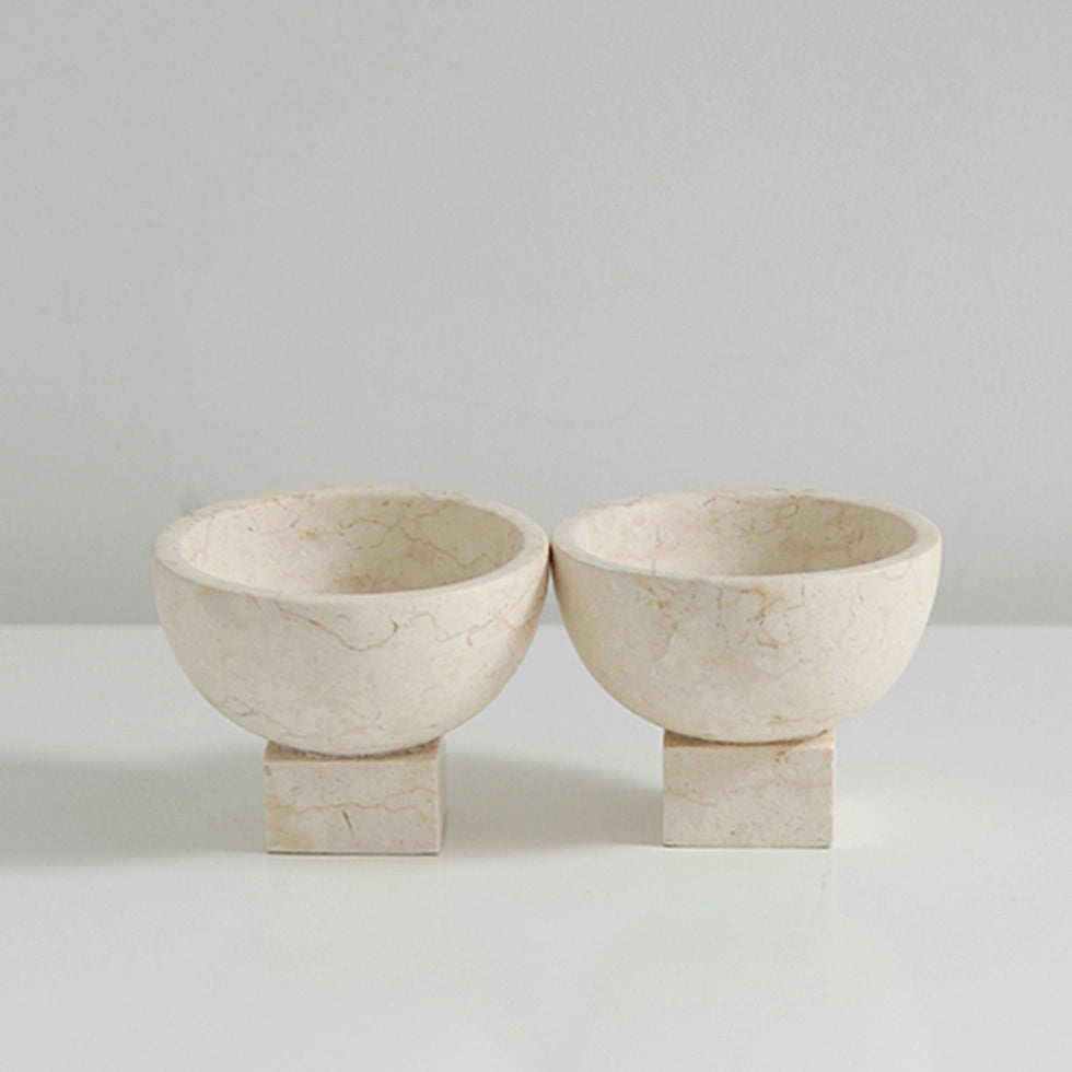 Two beige stone bowls on a light gray background
