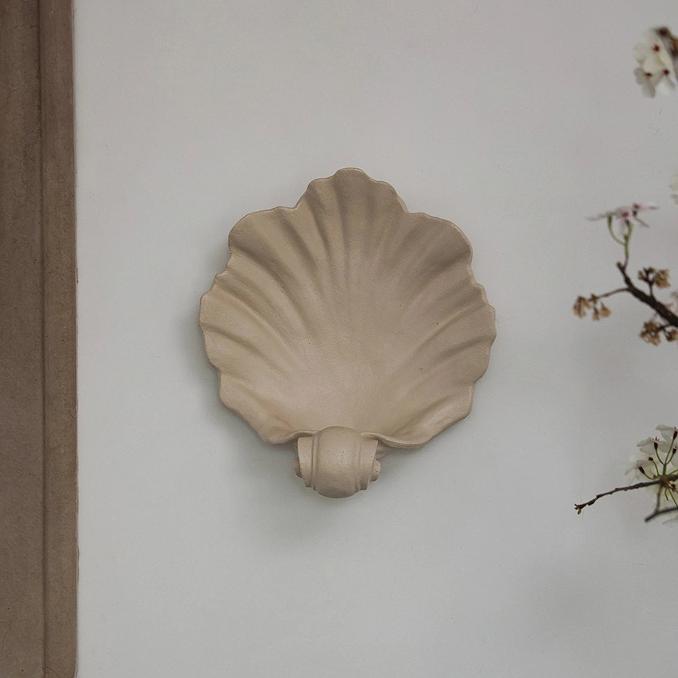 Off-white resin shell-shaped wall sconce for candles and decor